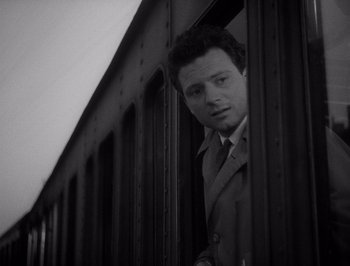 Movie still from “I Vitelloni” (1953), directed by Federico Fellini – A black and white photo of a man looking out of a train window; Medium shot, Low angle