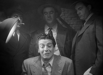 Movie still from “I Wake Up Screaming” (1941), directed by H. Bruce Humberstone – A group of men in suits and hats smoking and talking; Medium shot, Low angle