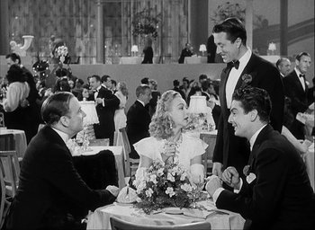 Movie still from “I Wake Up Screaming” (1941), directed by H. Bruce Humberstone – A group of people sitting around a table at an event; Medium shot, High angle