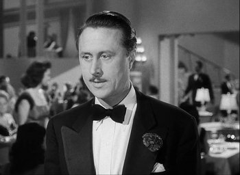 Movie still from “I Wake Up Screaming” (1941), directed by H. Bruce Humberstone – A black and white photo of a man in a tuxedo; Close Up shot, Low angle