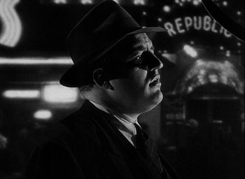 Movie still from “I Wake Up Screaming” (1941), directed by H. Bruce Humberstone – A black and white photo of a man in a suit and hat; Close Up shot, Low angle