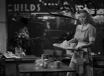 Movie still from “I Wake Up Screaming” (1941), directed by H. Bruce Humberstone – A woman in an apron is holding a tray of food; Medium shot, Low angle