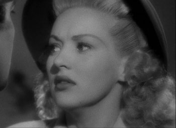 Movie still from “I Wake Up Screaming” (1941), directed by H. Bruce Humberstone – A black and white photo of a woman in a hat; Close Up shot, Over the shoulder angle