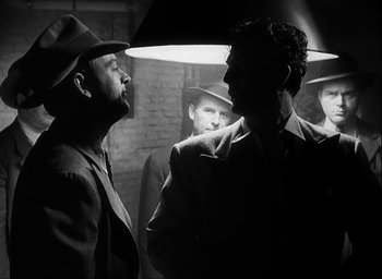 Movie still from “I Wake Up Screaming” (1941), directed by H. Bruce Humberstone – Two men in suits and hats are facing each other; Medium shot, Over the shoulder angle
