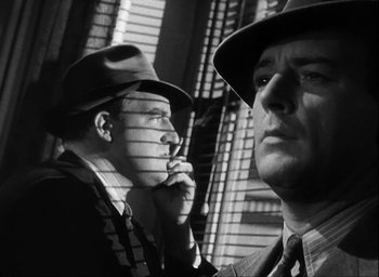 Movie still from “I Wake Up Screaming” (1941), directed by H. Bruce Humberstone – Two men in suits and hats are standing next to each other; Close Up shot, Low angle