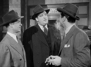 Movie still from “I Wake Up Screaming” (1941), directed by H. Bruce Humberstone – A group of men standing next to each other wearing hats; Medium shot, Low angle