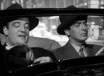 Movie still from “I Wake Up Screaming” (1941), directed by H. Bruce Humberstone – A couple of men sitting in the back seat of a car; Close Up shot, Low angle