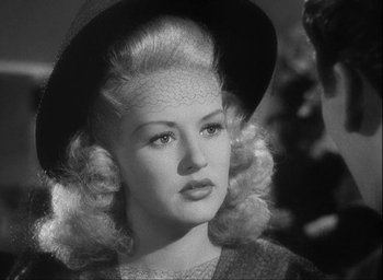 Movie still from “I Wake Up Screaming” (1941), directed by H. Bruce Humberstone – A black and white photo of a woman in a hat; Close Up shot, Over the shoulder angle