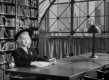 Movie still from “I Wake Up Screaming” (1941), directed by H. Bruce Humberstone – A woman sitting at a table in front of a window; Wide shot, Low angle