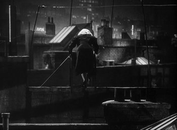 Movie still from “I Wake Up Screaming” (1941), directed by H. Bruce Humberstone – A woman is sweeping the roof of a building at night; Wide shot, Overhead angle