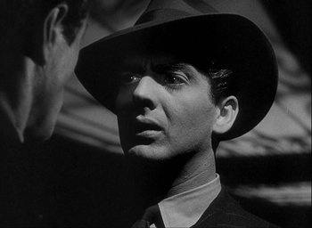 Movie still from “I Wake Up Screaming” (1941), directed by H. Bruce Humberstone – A black and white photo of a man wearing a hat; Close Up shot, Over the shoulder angle