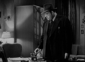 Movie still from “I Wake Up Screaming” (1941), directed by H. Bruce Humberstone – A black and white photo of a man in a suit and hat; Medium shot, Low angle