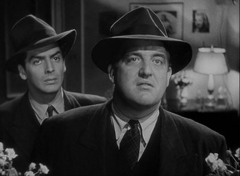 Movie still from “I Wake Up Screaming” (1941), directed by H. Bruce Humberstone – A man in a suit and hat standing next to another man in a hat; Close Up shot, Low angle