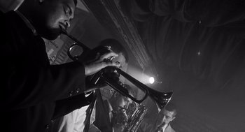Movie still from “I Want to Live!” (1958), directed by Robert Wise – A group of men playing musical instruments in a room; Extreme Close Up shot, Low angle