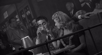 Movie still from “I Want to Live!” (1958), directed by Robert Wise – A man and a woman sitting at a table drinking wine; Medium shot, Over the shoulder angle