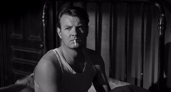Movie still from “I Want to Live!” (1958), directed by Robert Wise – A black and white photo of a man smoking a cigarette; Close Up shot, Low angle