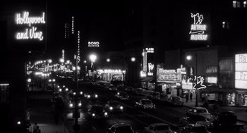 Movie still from “I Want to Live!” (1958), directed by Robert Wise – A black - and - white photo of a busy street at night; Extreme Wide shot, High angle