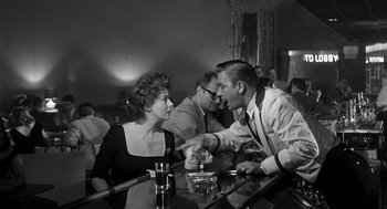 Movie still from “I Want to Live!” (1958), directed by Robert Wise – A man and a woman sitting at a bar talking to each other; Medium shot, Over the shoulder angle