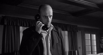 Movie still from “I Want to Live!” (1958), directed by Robert Wise – A man holding a phone up to his ear; Close Up shot, Low angle