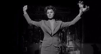 Movie still from “I Want to Live!” (1958), directed by Robert Wise – An old photo of a woman with her arms raised; Medium shot, Low angle