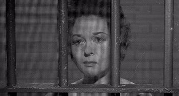 Movie still from “I Want to Live!” (1958), directed by Robert Wise – A black - and - white photo of a woman behind a fence; Close Up shot, Low angle