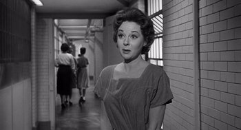 Movie still from “I Want to Live!” (1958), directed by Robert Wise – An old black and white photo of a woman standing in a hallway; Medium shot, Over the shoulder angle