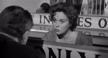 Movie still from “I Want to Live!” (1958), directed by Robert Wise – A woman sitting in front of a man in front of a sign; Close Up shot, Over the shoulder angle