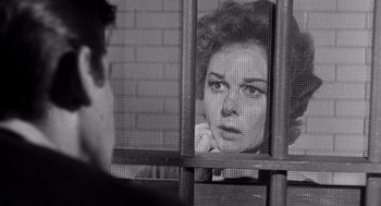 Movie still from “I Want to Live!” (1958), directed by Robert Wise – A black - and - white photo of a woman looking through a fence; Close Up shot, Over the shoulder angle
