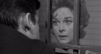 Movie still from “I Want to Live!” (1958), directed by Robert Wise – A woman looking at a man through a fence; Close Up shot, Over the shoulder angle