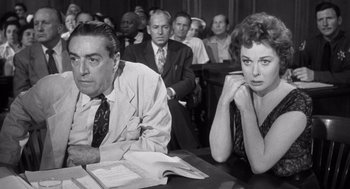 Movie still from “I Want to Live!” (1958), directed by Robert Wise – A man and a woman sitting at a table in front of other people; Medium shot, Low angle