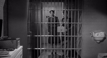 Movie still from “I Want to Live!” (1958), directed by Robert Wise – Two men standing in front of a jail cell; Wide shot, High angle