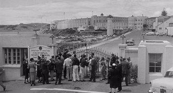 Movie still from “I Want to Live!” (1958), directed by Robert Wise – A group of people standing on the side of a road; Extreme Wide shot, High angle