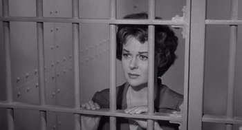 Movie still from “I Want to Live!” (1958), directed by Robert Wise – A black and white photo of a woman behind bars; Medium shot, Low angle