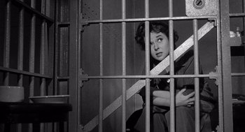 Movie still from “I Want to Live!” (1958), directed by Robert Wise – A black and white photo of a woman sitting in a jail cell; Medium shot, Low angle