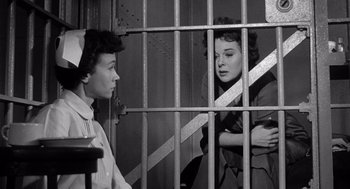 Movie still from “I Want to Live!” (1958), directed by Robert Wise – Two women are in a jail cell talking to each other; Medium shot, Low angle