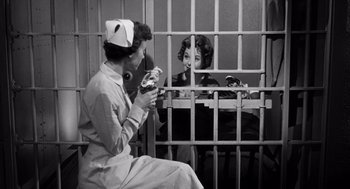 Movie still from “I Want to Live!” (1958), directed by Robert Wise – Two women sitting in front of a jail cell; Medium shot, Low angle
