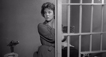 Movie still from “I Want to Live!” (1958), directed by Robert Wise – A black and white photo of a woman behind bars; Medium shot, Low angle