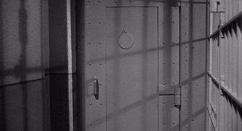 Movie still from “I Want to Live!” (1958), directed by Robert Wise – A black and white photo of a door; Wide shot, High angle