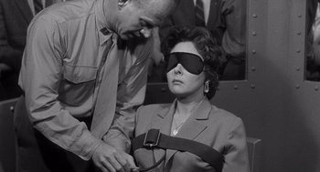 Movie still from “I Want to Live!” (1958), directed by Robert Wise – An old photo of a man and a blindfolded woman; Medium shot, High angle
