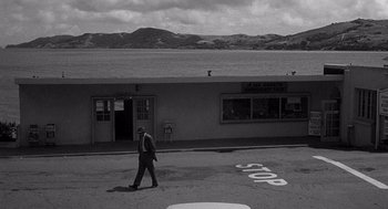Movie still from “I Want to Live!” (1958), directed by Robert Wise – A black and white photo of a man walking down the street; Extreme Wide shot, High angle