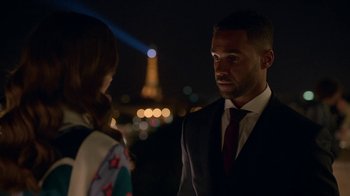 Movie still from “Emily in Paris” (2020), created by Darren Star – A man and a woman standing next to each other in front of the eiffel tower at night; Close Up shot, Over the shoulder angle