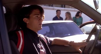 Movie still from “I'll Be Home for Christmas” (1998), directed by Arlene Sanford – A man sitting in the back seat of a car; Medium shot, Over the shoulder angle