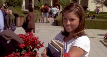Movie still from “I'll Be Home for Christmas” (1998), directed by Arlene Sanford – A woman holding a stack of books in her hands; Medium shot, Low angle
