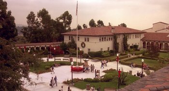 Movie still from “I'll Be Home for Christmas” (1998), directed by Arlene Sanford – A group of people standing in a courtyard with a building in the background; Extreme Wide shot, High angle