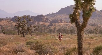 Movie still from “I'll Be Home for Christmas” (1998), directed by Arlene Sanford – A man in a santa clause costume in a field; Extreme Wide shot, High angle