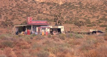 Movie still from “I'll Be Home for Christmas” (1998), directed by Arlene Sanford – An old gas station in the middle of a desert landscape; Extreme Wide shot, High angle