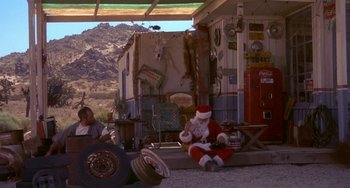 Movie still from “I'll Be Home for Christmas” (1998), directed by Arlene Sanford – A man sitting on the side of the road next to an rv; Wide shot, High angle