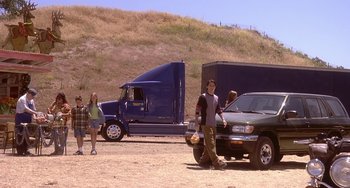 Movie still from “I'll Be Home for Christmas” (1998), directed by Arlene Sanford – A group of people standing next to a truck; Extreme Wide shot, High angle
