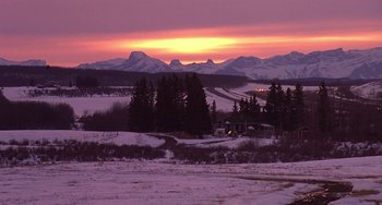 Movie still from “I'll Be Home for Christmas” (1998), directed by Arlene Sanford – The sun is setting over a snowy field; Extreme Wide shot, High angle