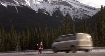 Movie still from “I'll Be Home for Christmas” (1998), directed by Arlene Sanford – A man dressed as santa claus standing on the side of the road; Extreme Wide shot, High angle
